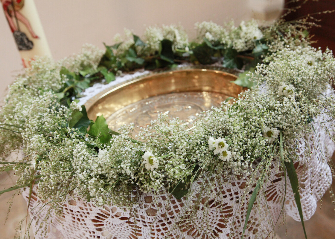 Taufbecken mit Blumenkranz