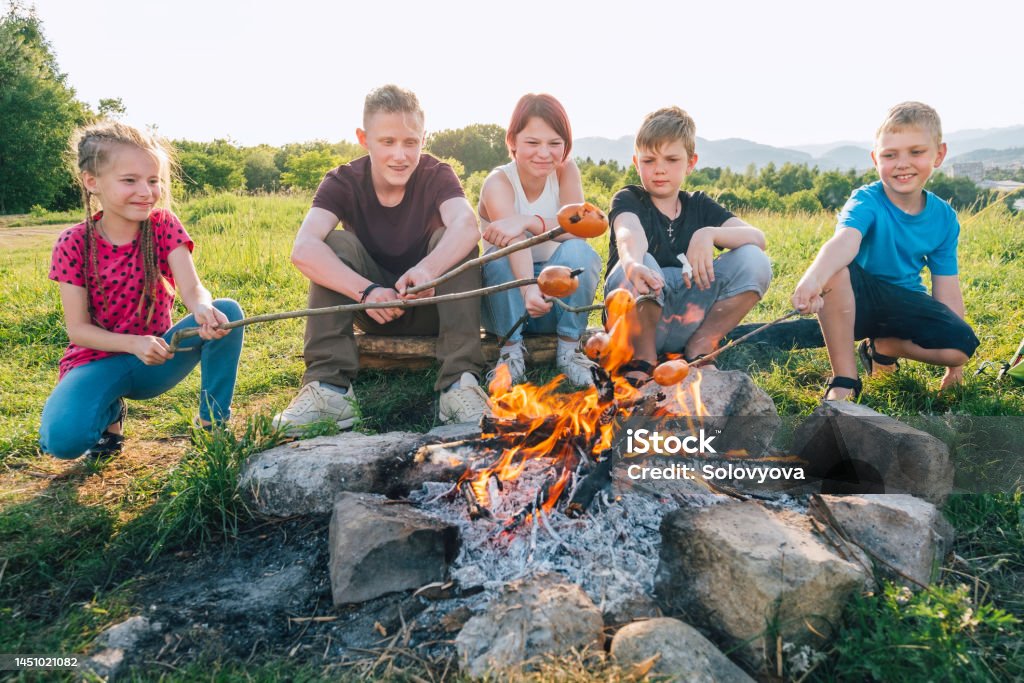 Gruppe Jugendlicher, die am Lagerfeuer sitzen